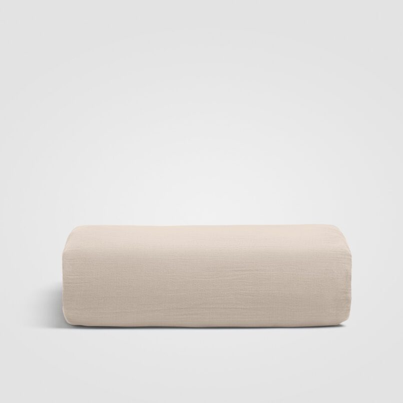 Folded beige sheet on white background