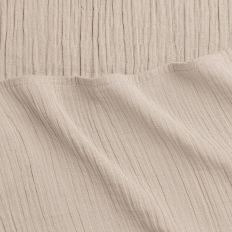 Cream woven fabric with slight folds and subtle vertical lines