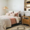 Bed  with rust, beige, and cream pillows in a cozy room with warm decor