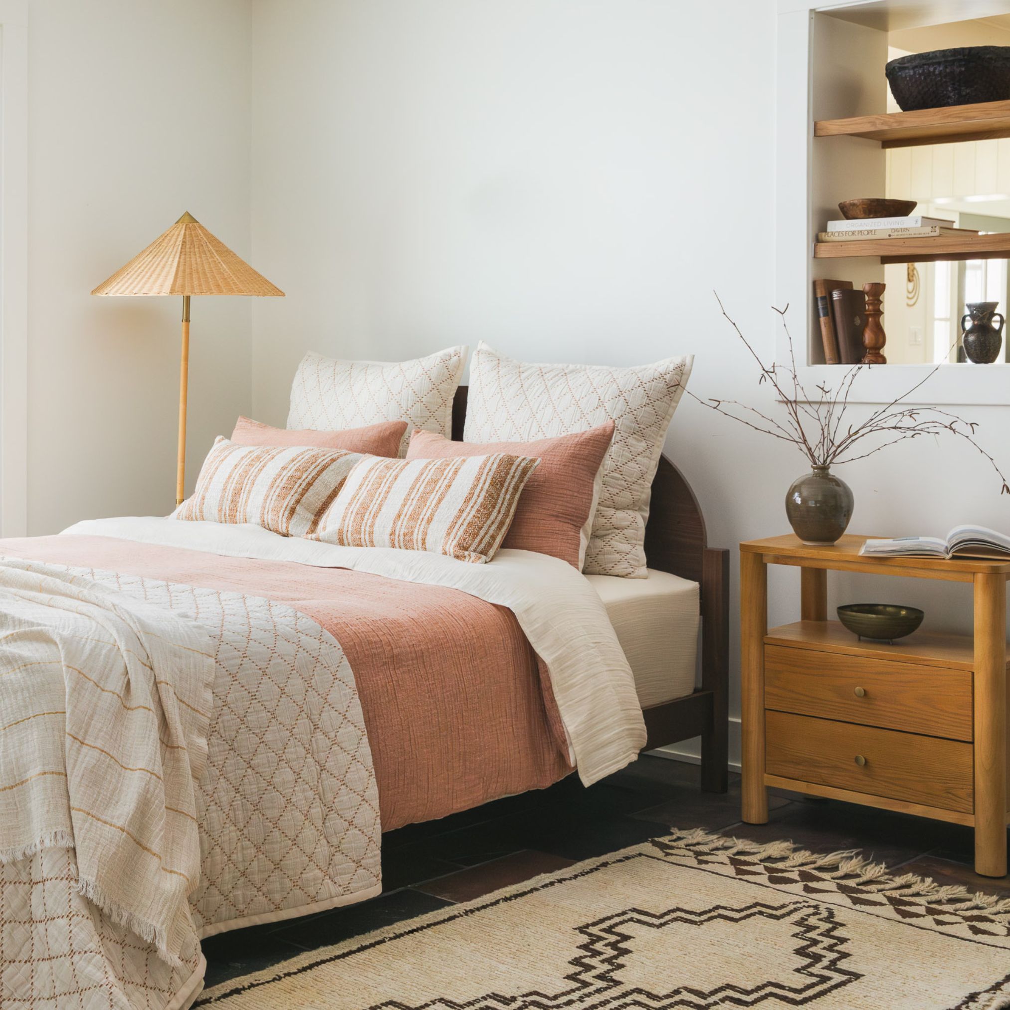 9 Bed with rust, beige, and cream pillows in a cozy room with warm decor
