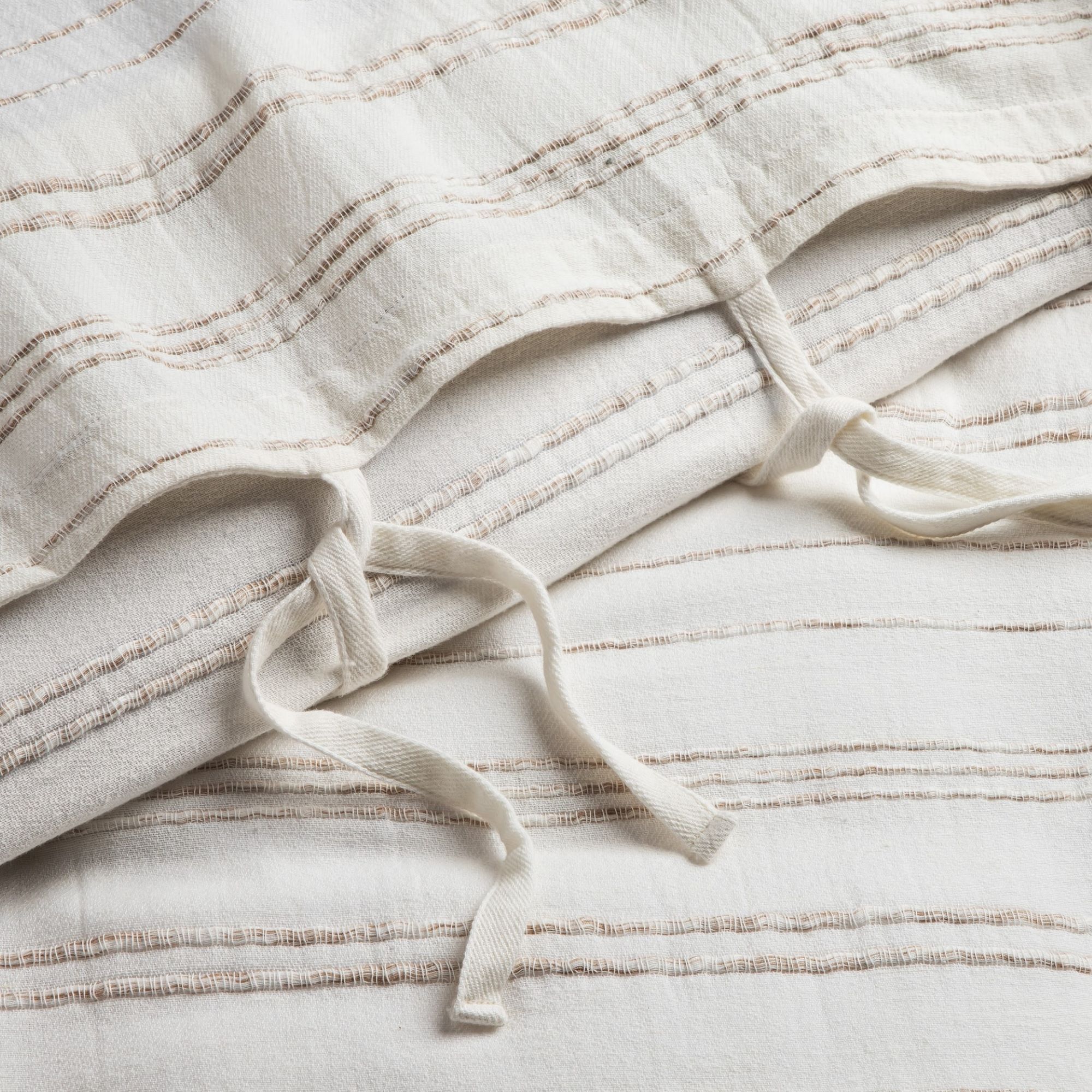 Close-up of soft white sheets with gentle folds and smooth texture
