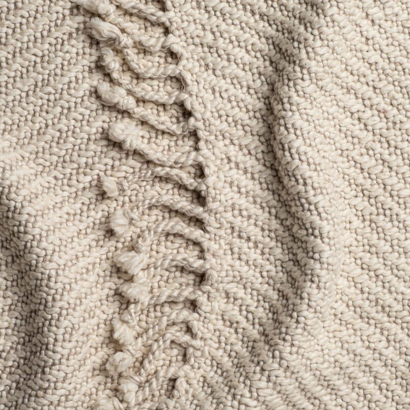 Close-up of cable knit throw with mixed braided and ribbed patterns