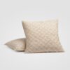 Decorative cream pillow with diamond pattern stitching on a white background