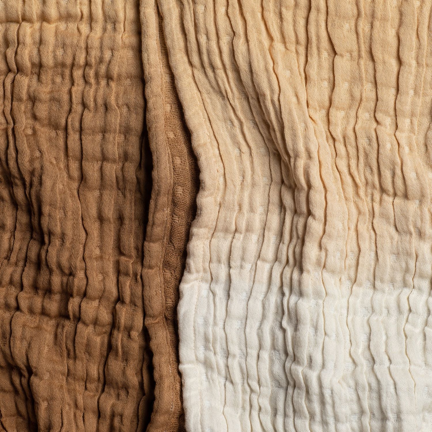 Close-up of beige and rust cable knit throw blanket with braided texture