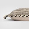 Folded rectangular pillow with a beige base and black stitched accents