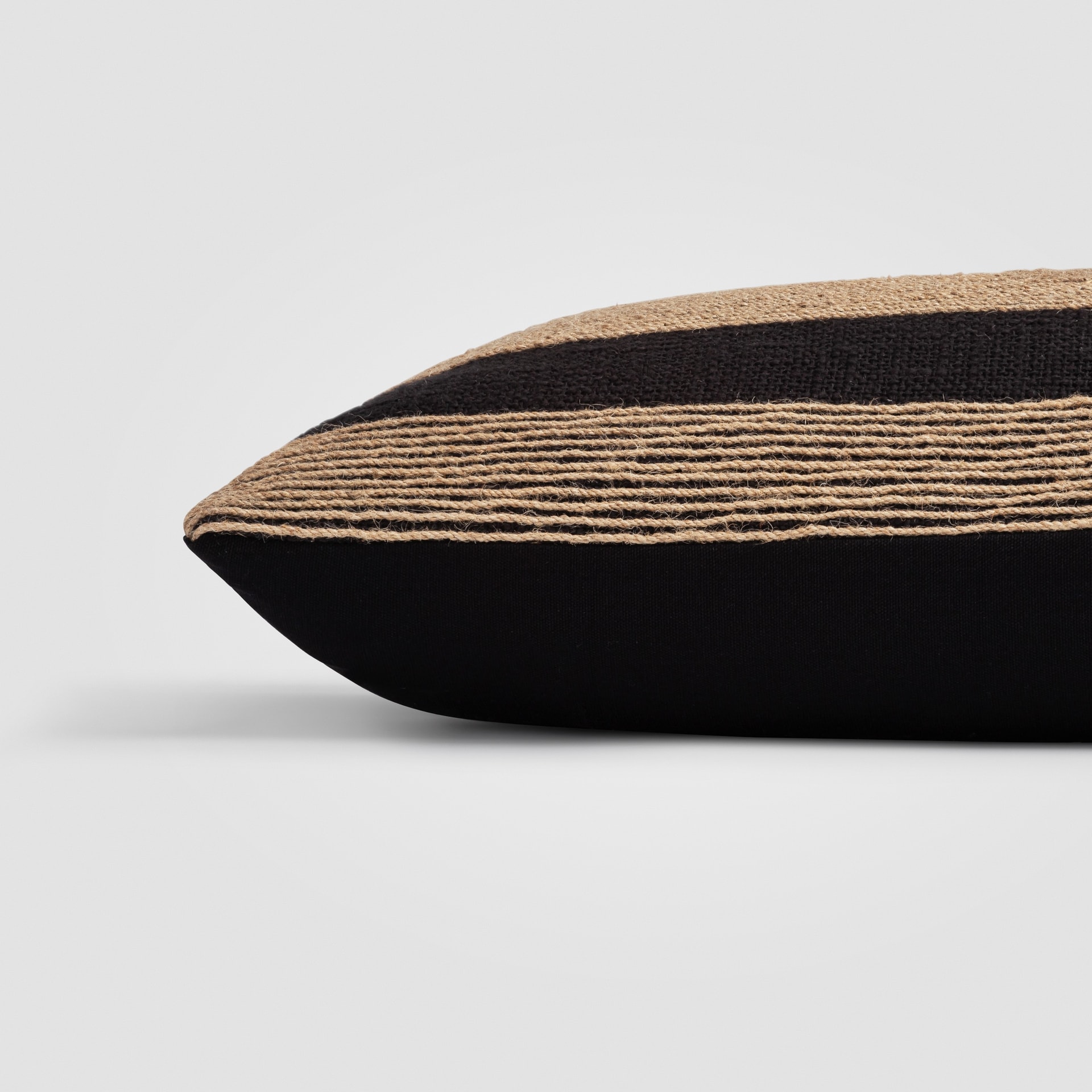 Side profile of a black and tan pillow with woven pattern