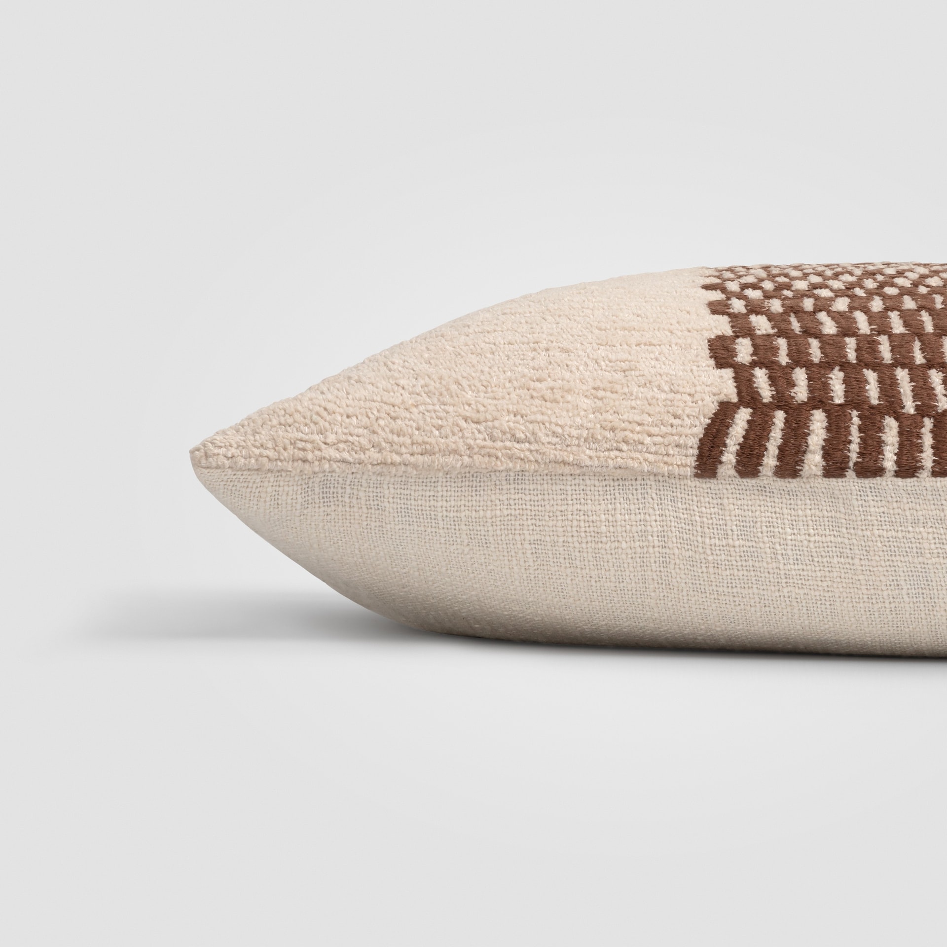 Rectangular beige pillow with horizontal black stripe across the center