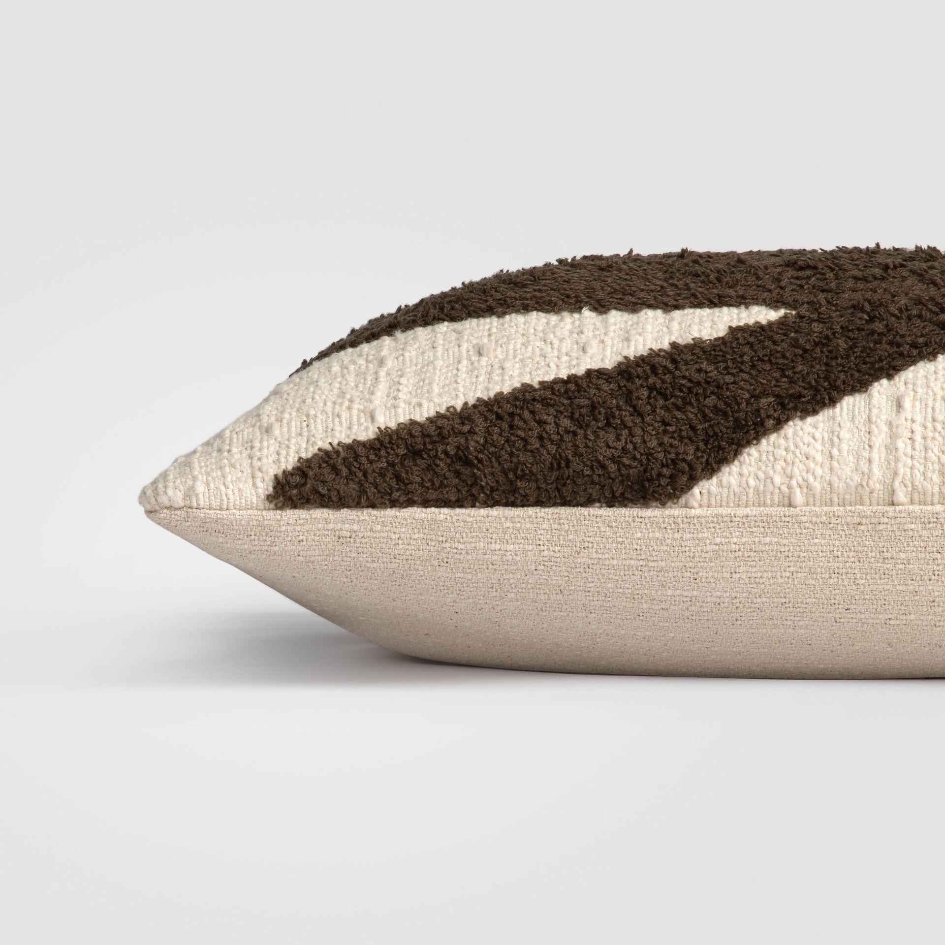 Side view of a beige and brown pillow with color-blocked stripe design