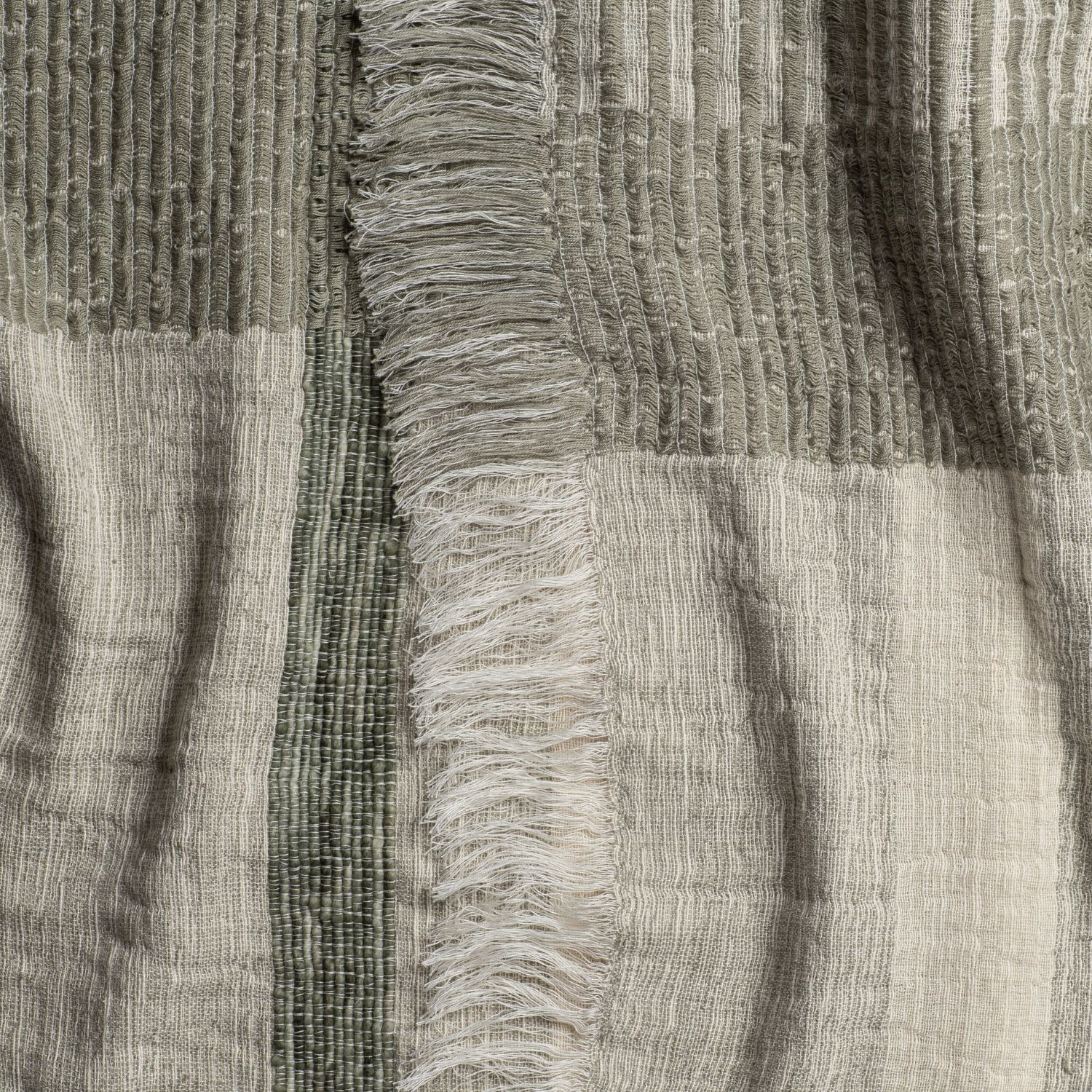 Close-up of olive green and beige striped knit throw with subtle ribbed weave