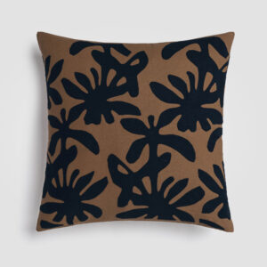 Dark blue pillow with a brown botanical leaf pattern on the front
