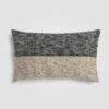 Long rectangular pillow with geometric black and cream pattern and fringe trim