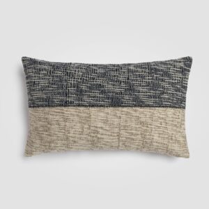 Long rectangular pillow with geometric black and cream pattern and fringe trim
