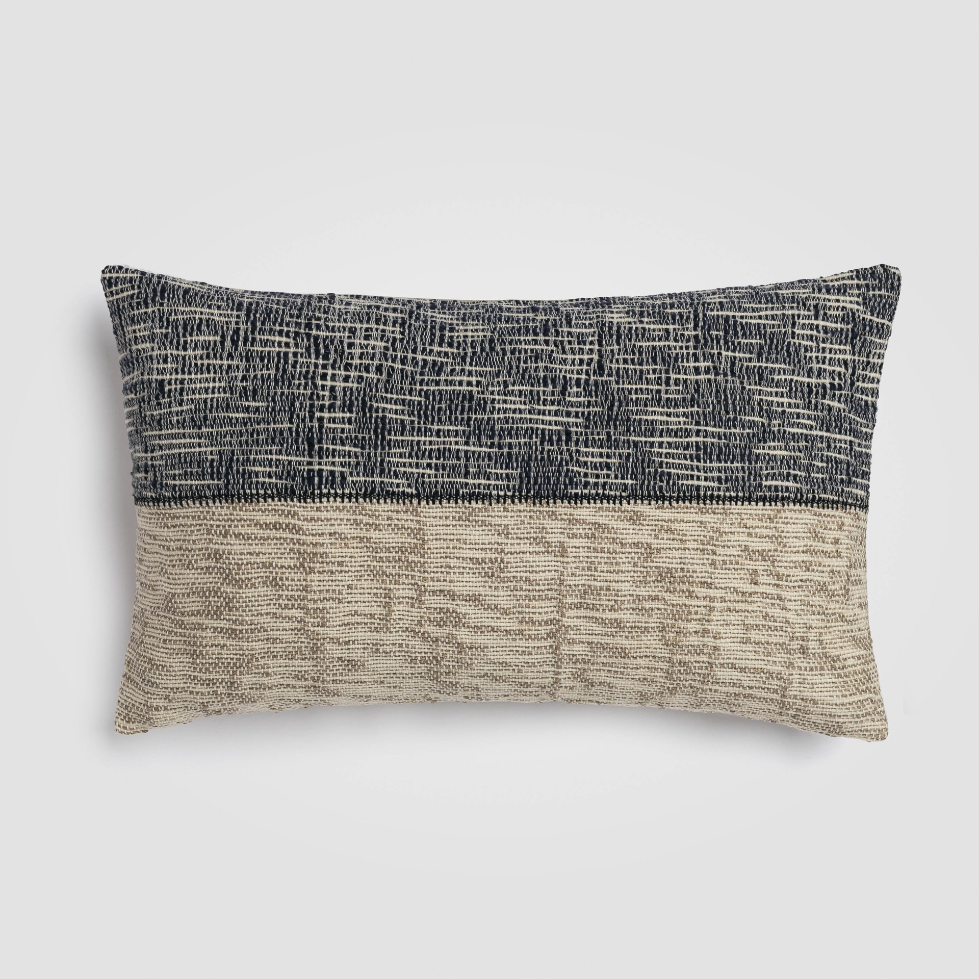 Long rectangular pillow with geometric black and cream pattern and fringe trim