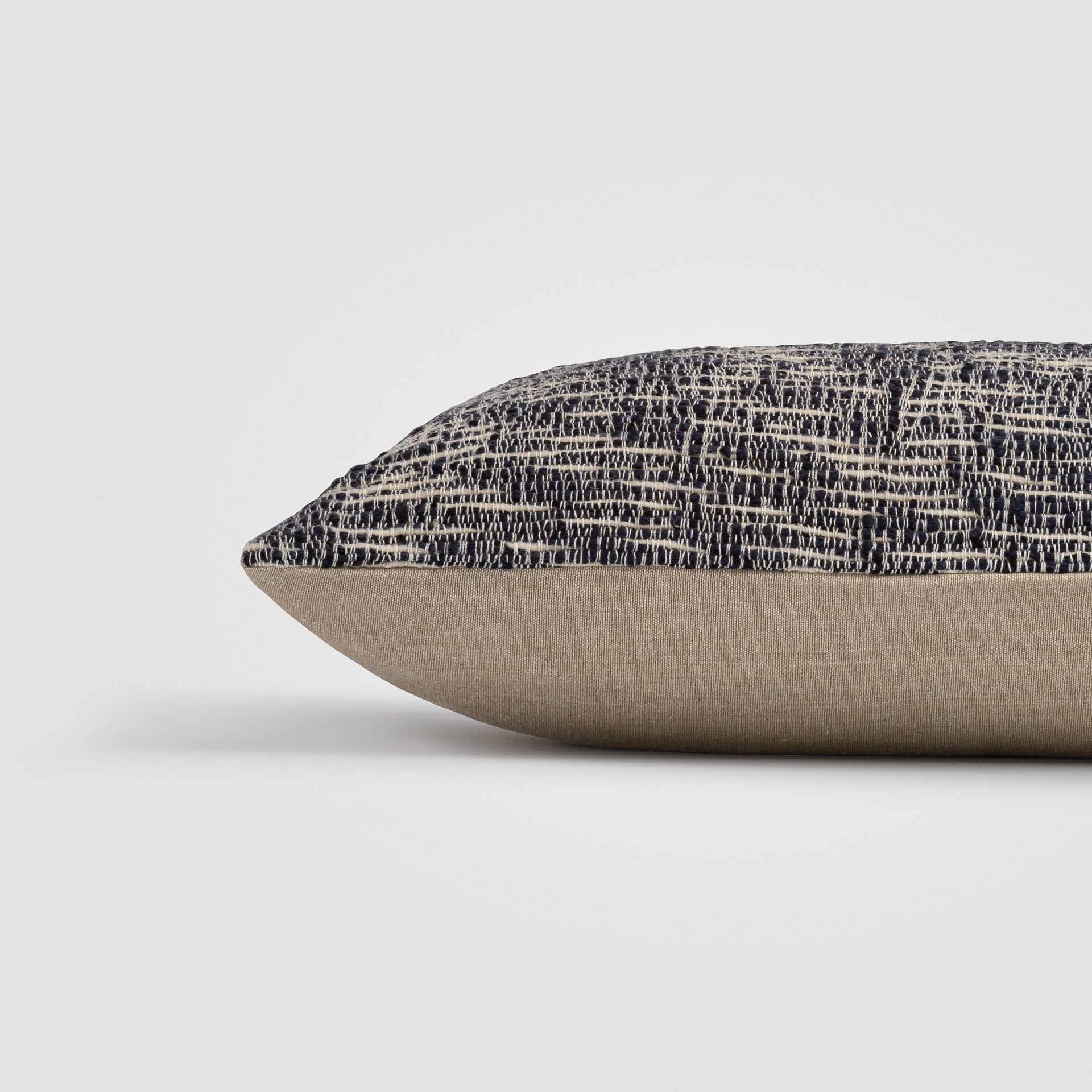 Rectangular pillow with black, cream, and tan woven pattern and textured surface