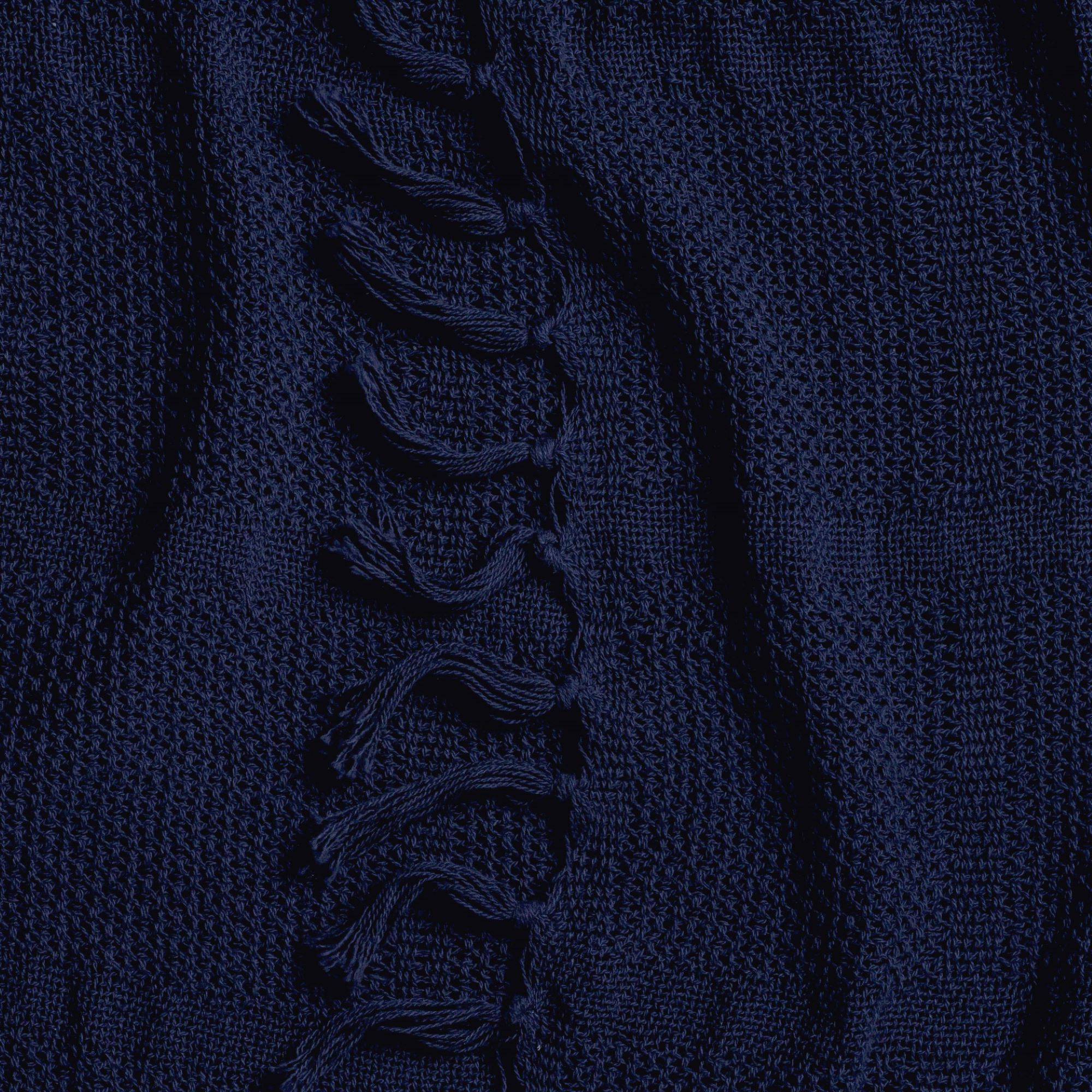 Close-up of dark navy knit throw blanket showing braided texture detail