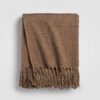 Beige throw blanket folded on a white background