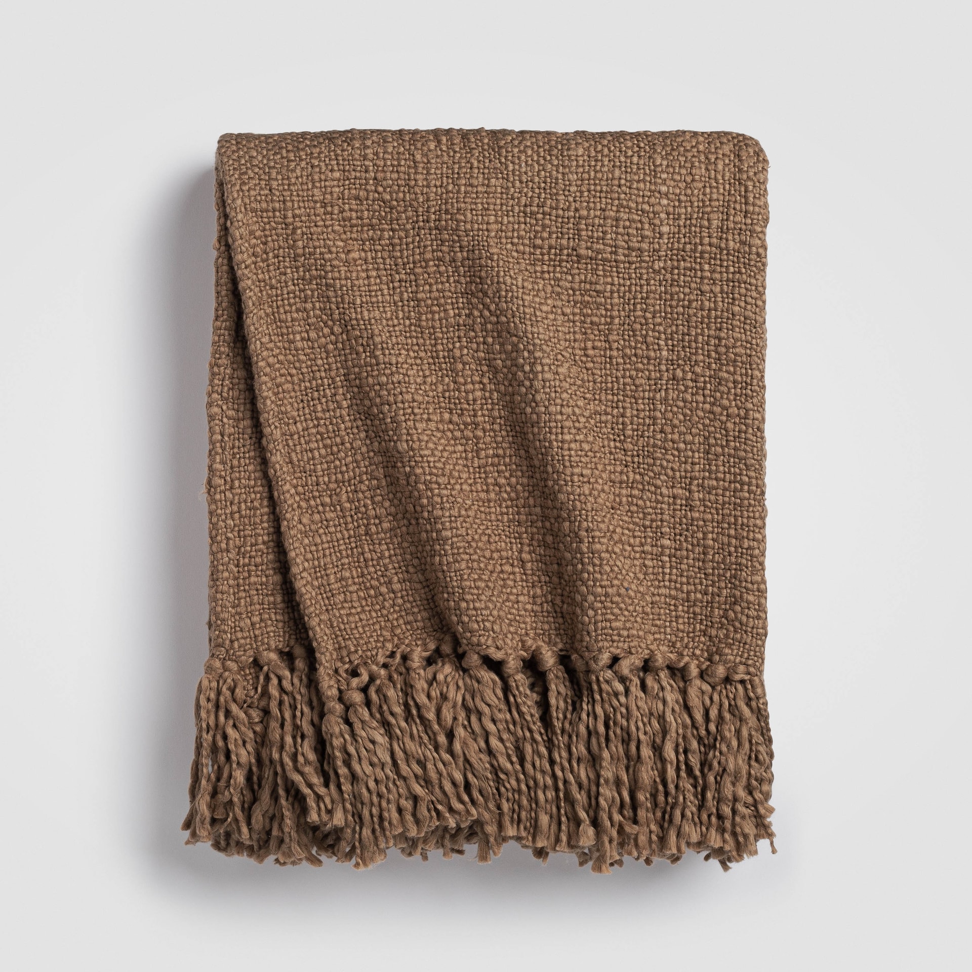 Beige throw blanket folded on a white background