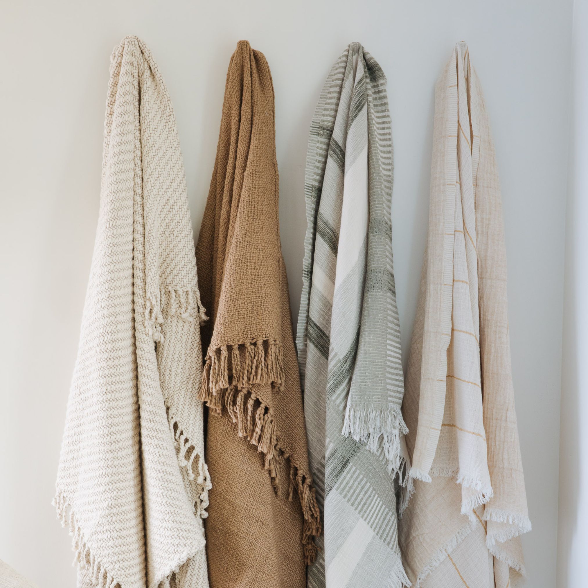4 throw blankets hanging on wall hooks