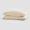 Beige pillowcases stacked on a plain white surface