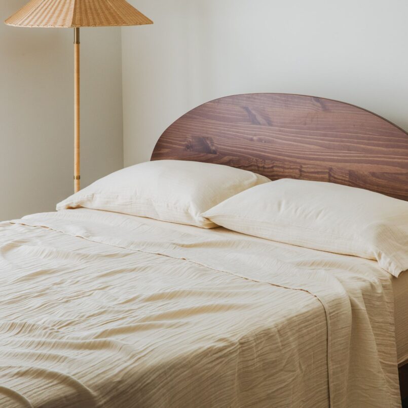 Neutral bed with textured throw blanket and pillows in a coy room
