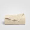 Cream-colored sheet with a subtle stitched design on a white background