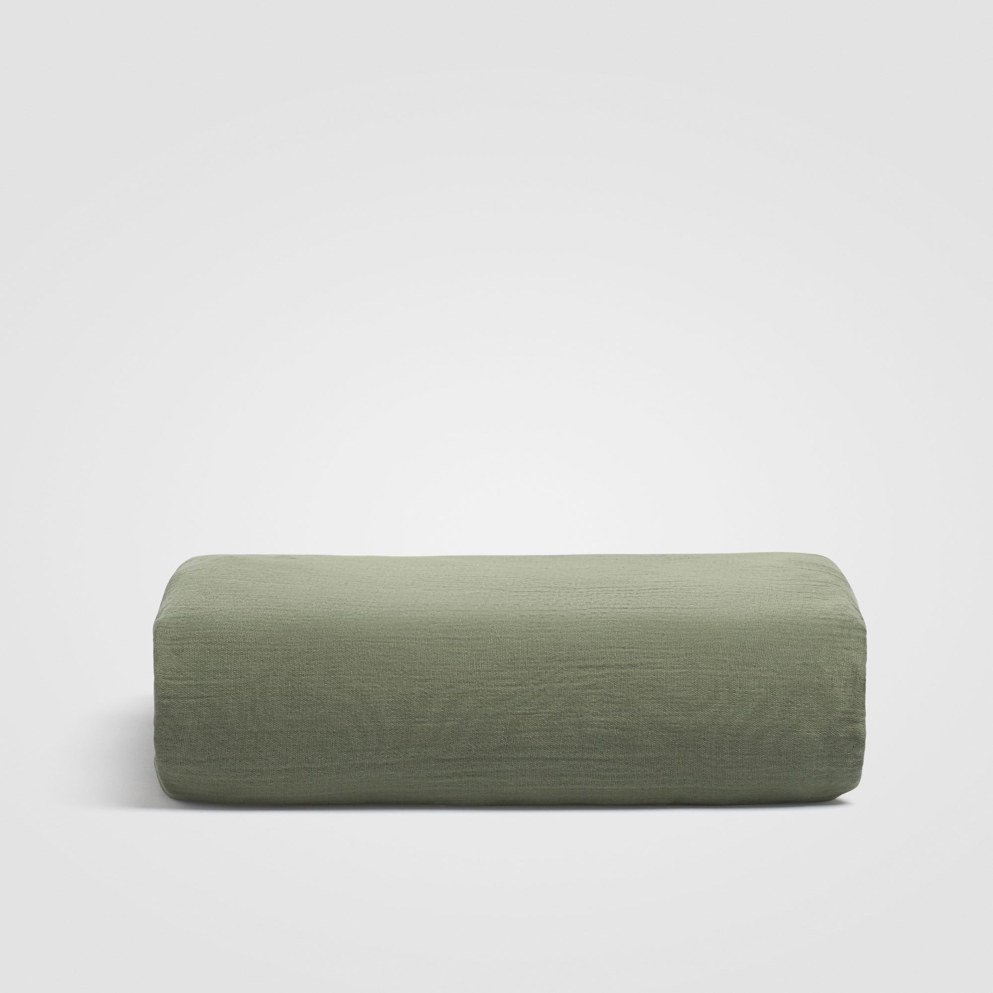 Folded sage green sheet stacked on a white background