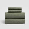 Set of three sage green sheet neatly stacked on a white background