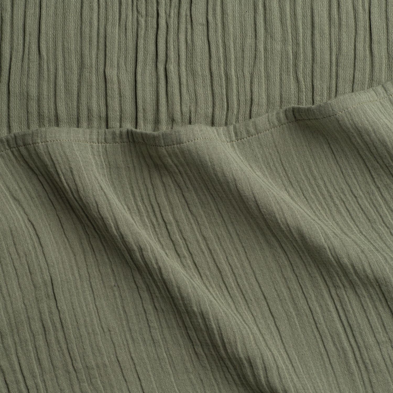 Close-up of sage green woven fabric with visible texture