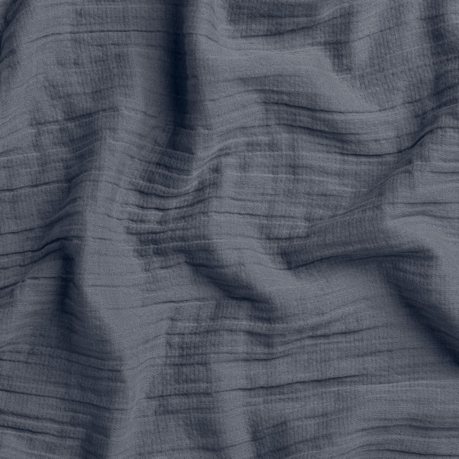 Close-up of dark blue woven fabric with visible texture and stitching