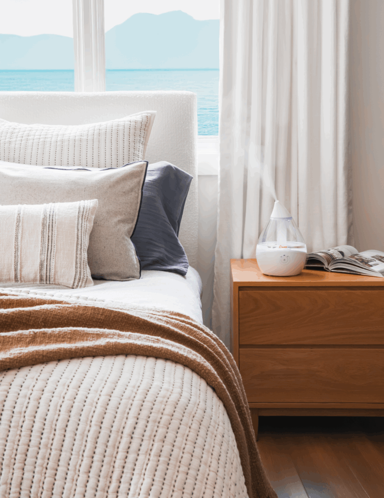 Humidifier on a nightstand next to a bed 