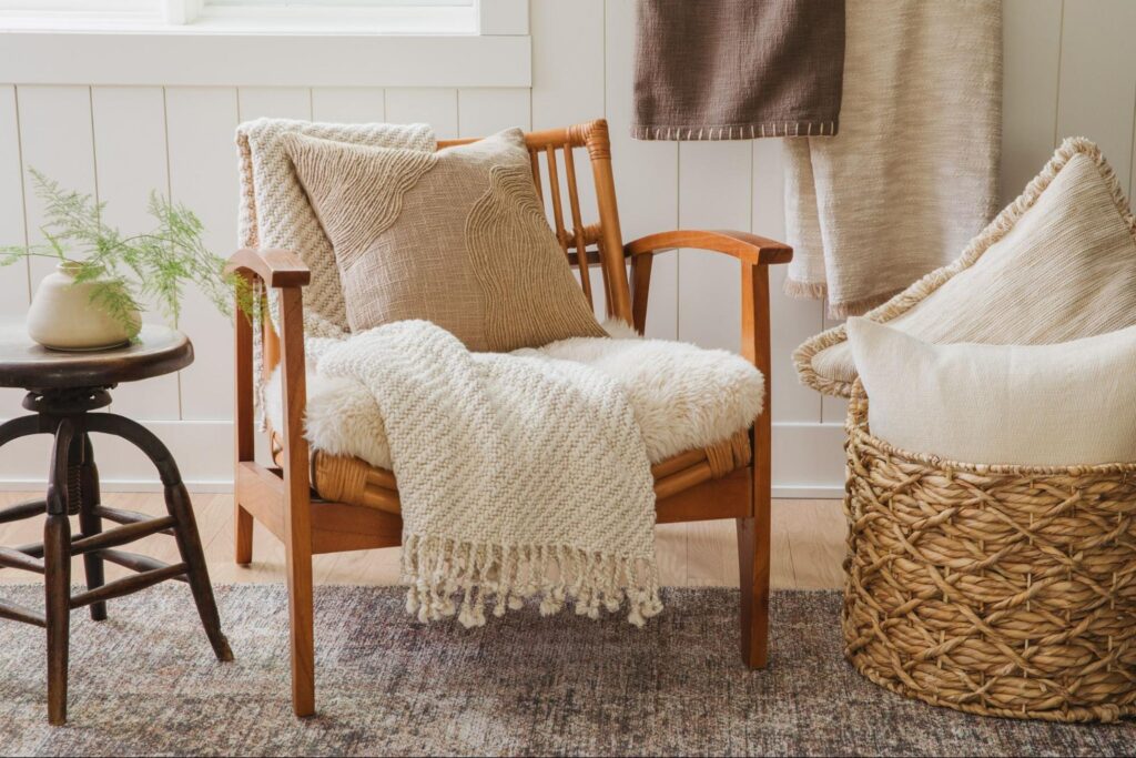 Chair with a white throw blanket and brown textured accent pillow